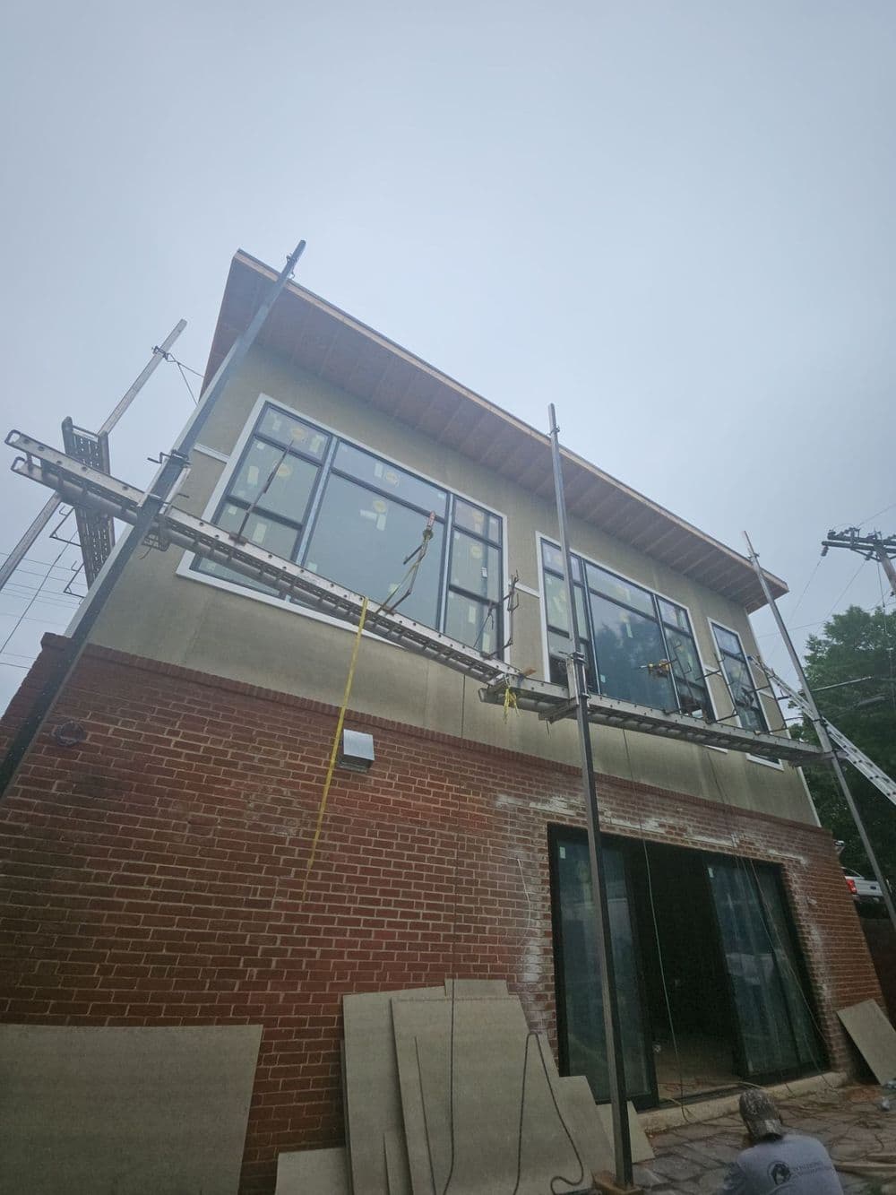 Newly constructed building with large windows and scaffolding, showcasing modern architecture.