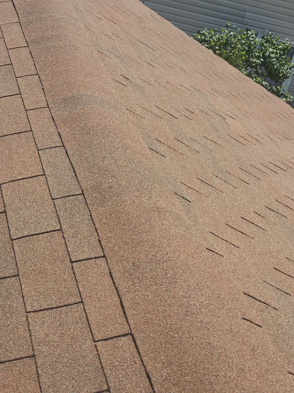 Close-up of a brown asphalt shingle roof showing texture and pattern for roofing detail.